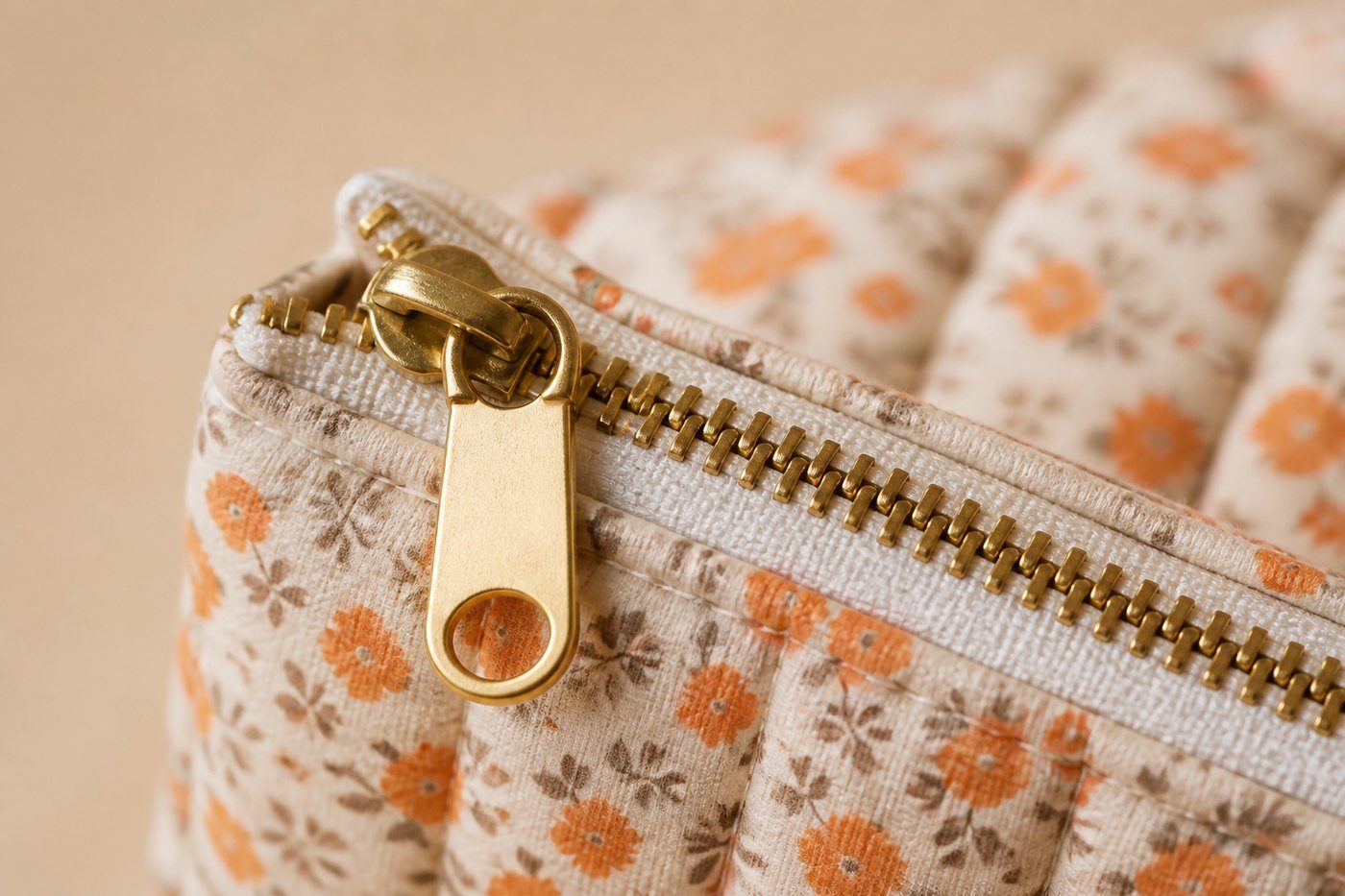 Une fermeture dorée et une couture sur le tissu fleuri